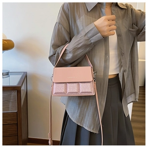 Detail of pink crossbody bag with Fashion & Bags text and quilted texture on synthetic leather