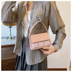 Detail of pink crossbody bag with sequined chocolate texture and top handle on a model