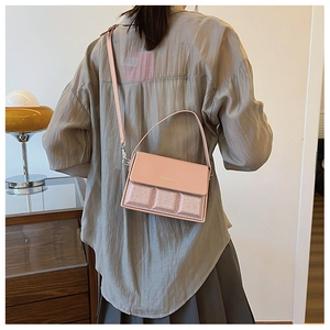 Detail of pink fashion bag with glitter texture and dual straps shown on a model