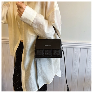 Detail of sequin patchwork and 'FASHION & BAGS' text on the black crossbody bag