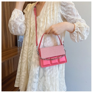 Pink box bag with chocolate block texture and metallic chain detail on fashion model