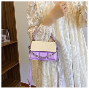 Close-up of dual-tone crossbody box bag featuring purple chocolate textured relief and chain