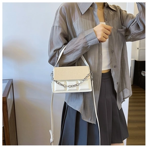 Detailed shot of two-tone crossbody bag featuring woven texture and chocolate block pattern