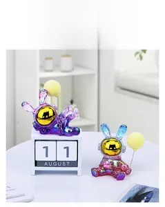 Close-up of dual iridescent rabbit astronaut figurines with metallic purple gradient finish