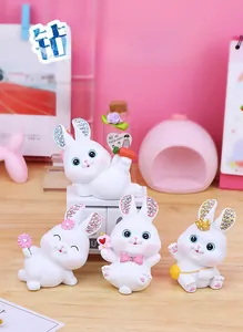 Close-up of four cute resin rabbit figurines with colorful rhinestones on ears