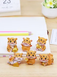 Set mit sechs süßen Tigerfiguren aus Harz auf Holzschreibtisch mit Büroartikel