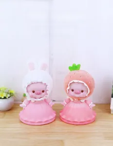 Detailed shot of pig piggy banks wearing strawberry and rabbit hats on wooden table