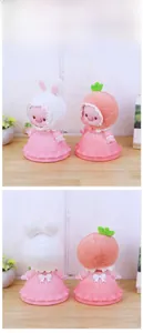 Detail showing front and back of pig money bank with lace hat and ribbon dress