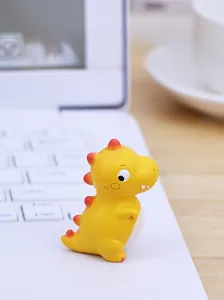 Mini Gelber Dino-Figur als niedliche Schreibtischdeko auf einer Tastatur