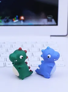 Nahaufnahme von süßen grünen und blauen Dinosaurier-Figuren auf einer Laptop-Tastatur