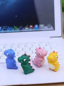 Set mit vier bunten Mini-Dinosaurier-Figuren in Mattoptik auf einer Tastatur