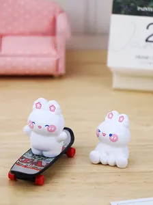 Miniature resin rabbit figurines with cherry blossom accents on a skateboard and sofa