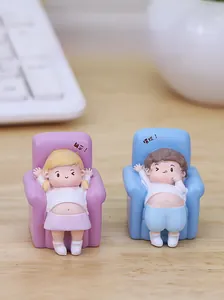 Cute cartoon couple figurines in lying position on office desk with white keyboard background