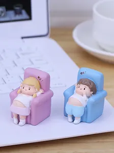 Relaxed cute couple figurines in blue and pink sofas on a white laptop keyboard