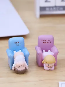 Close-up of cute resin figurines sitting on miniature chairs for desktop car decoration