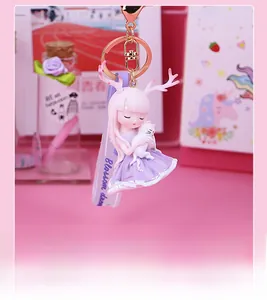 Detail of pink-haired deer girl keychain with white cat and Blossom dream wrist strap
