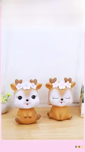 Close-up of cute cartoon deer figurines with pastel floral crowns on a clean table