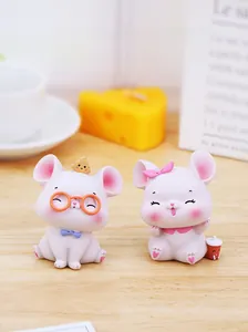 Gros plan de figurines de souris roses mignonnes en résine avec accessoires de fromage
