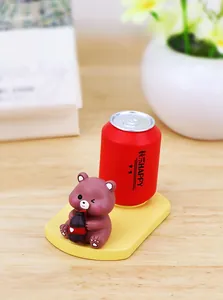 Cute brown bear figurine on yellow base with red soda can for desktop decor