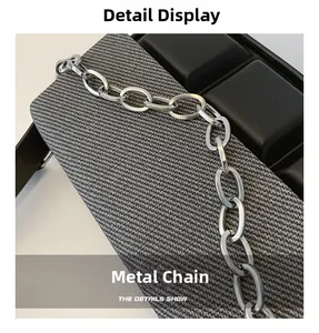 Macro shot of durable silver hardware chain on a minimalist crossbody box bag