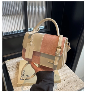 Detail of color-block leather crossbody bag with metal buckle and fashion logo tag