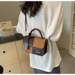 Detail of contrast stitching and dual-material PU and suede leather on top handle bag