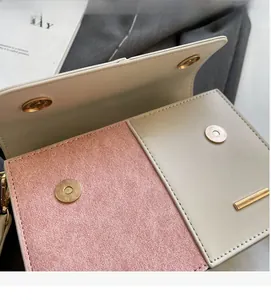 Close-up of contrast color handbag featuring shiny pink fabric and magnetic gold buckle