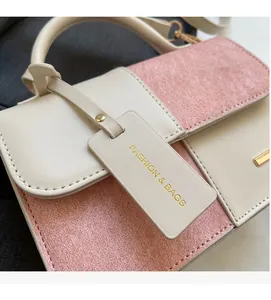 Detail of color-block tote bag with beige leather, pink suede, and metal trim