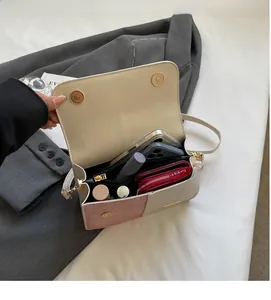 Detail of color-block crossbody bag showing interior compartments and magnetic closure