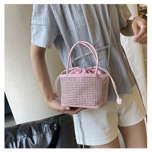 Close-up of pink rhinestone bucket bag with drawstring closure and silver chain strap