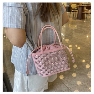 Close-up of pink bucket bag featuring silver stud details and metal chain strap