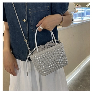 Detail of silver rhinestone bucket bag showing sparkling crystals and drawstring closure