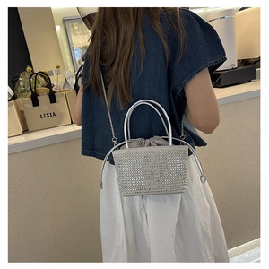 Detail of silver rhinestone bucket bag with drawstring liner and elegant chain strap