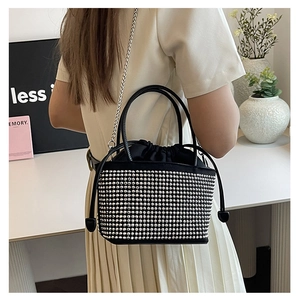 Close-up of black bucket bag featuring silver rhinestones and a metal chain strap