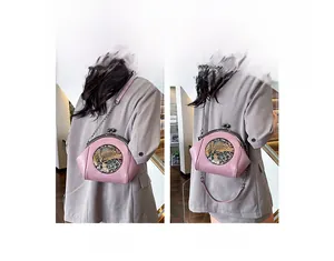 Detail of pink vintage shell bag featuring litchi leather and metal chain strap