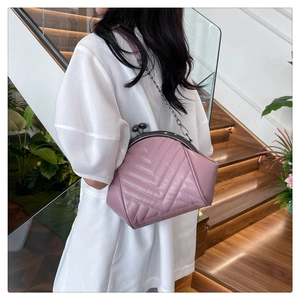Pale pink quilted shell bag with V-shaped stitching and vintage metal kiss-lock closure