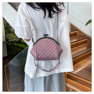 Detailed view of lavender pink shell bag featuring V-shaped quilting and chain strap