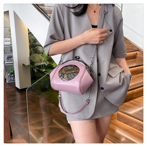 Close-up of pink leather shell bag featuring vintage metal clasp and relief pattern details