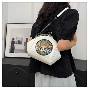 Detail of vintage shell bag with retro elephant relief and metal chain strap