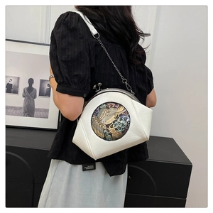Detail of vintage shell bag with elephant relief and gunmetal chain strap in white