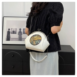 Detailed view of white vintage shell bag with gold elephant relief and metal chain strap