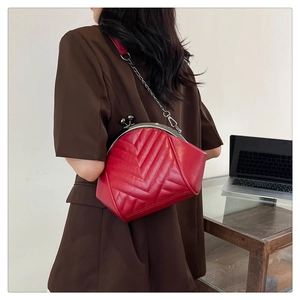 Detail of red chevron quilted leather bag with silver chain strap and kiss-lock closure
