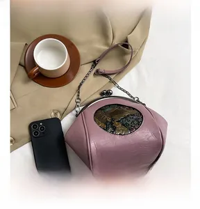 Retro purple shell bag with elephant relief compared to smartphone size for scale
