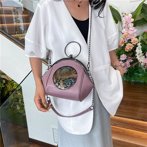 Fashionable purple shell bag with elephant relief and metal ring handle displayed by model