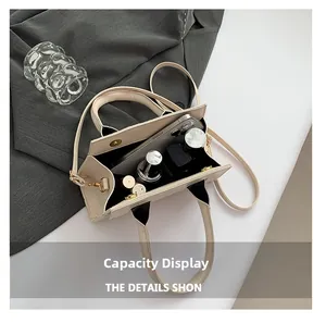 Internal capacity of the cream faux-leather bag showing phone and cosmetics