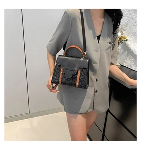 Détail du sac à bandoulière bicolore marron et noir avec texture crocodile élégante