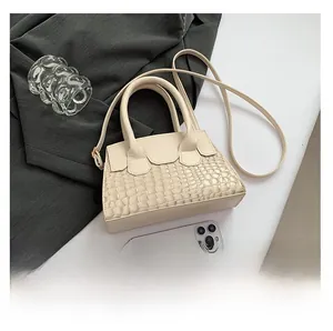 Mini off-white crossbody bag with crocodile texture and phone for size comparison