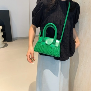Green faux crocodile leather handbag shown on model for a trendy french style look
