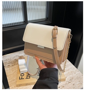 Detail of color-block crossbody bag with cream flap and adjustable leather strap