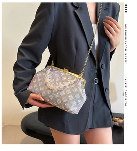 Detail of sequined crossbody bag with bead handle and chain strap on a model